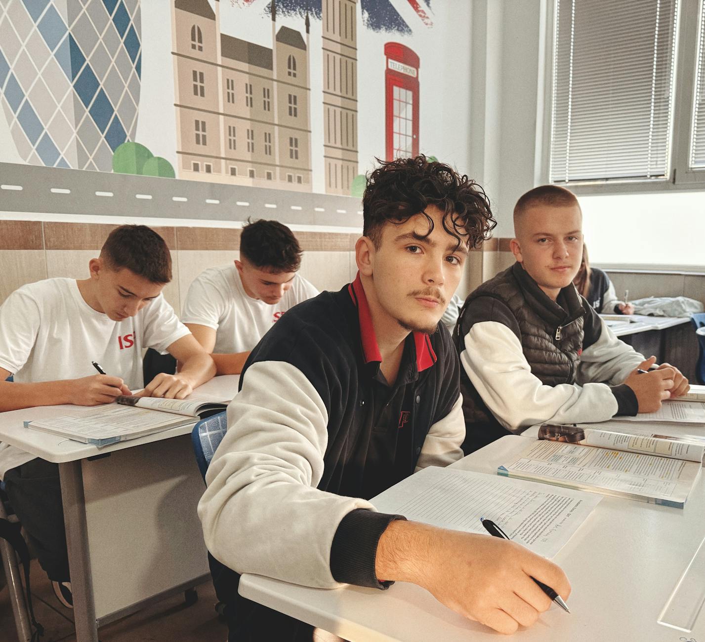 Uczniowie liceum wracają do nauki w klasie z brytyjskimi plakatami