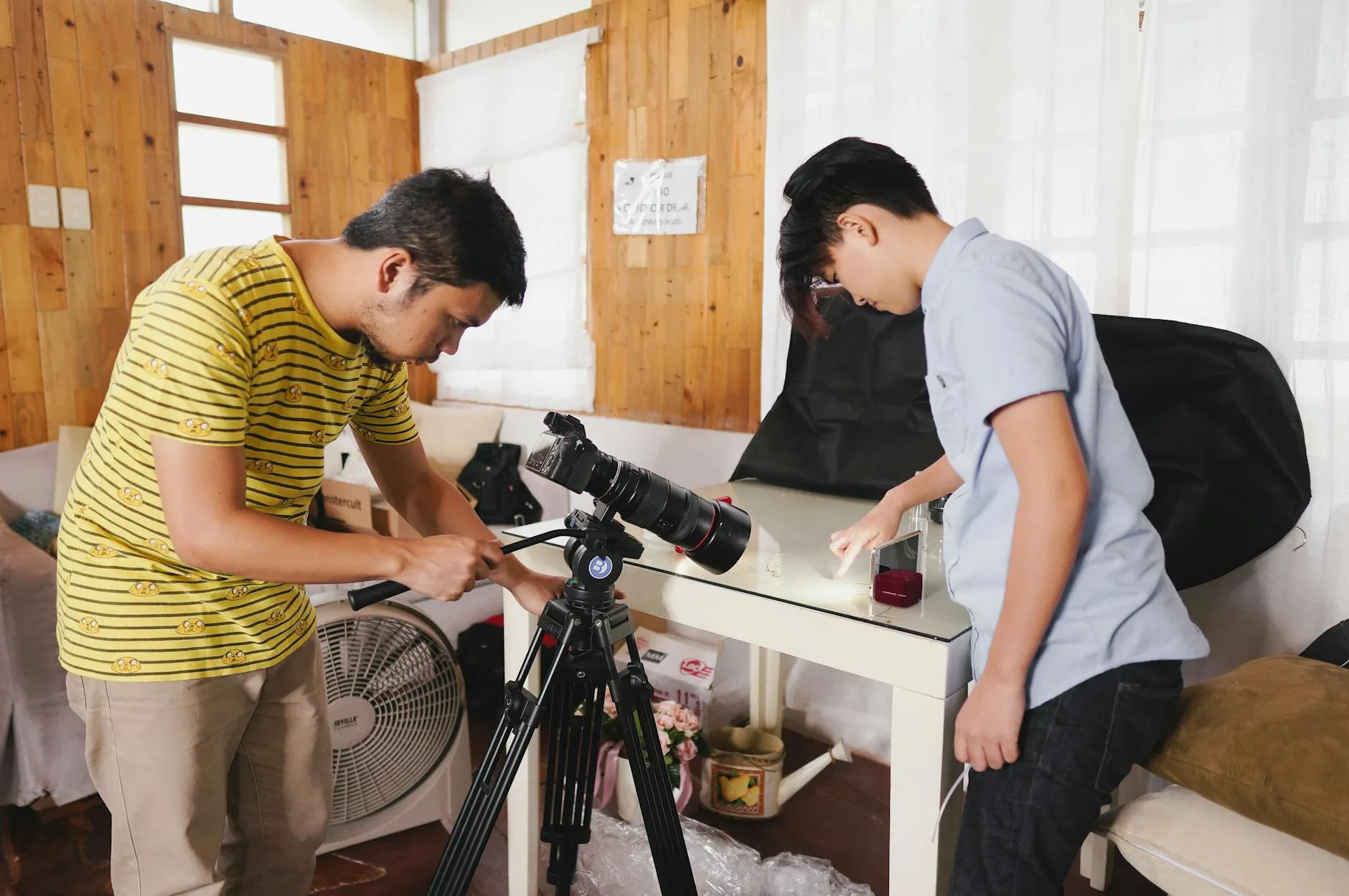 Dwójka młodych ludzi ustawia sprzęt fotograficzny w szkolnym studio