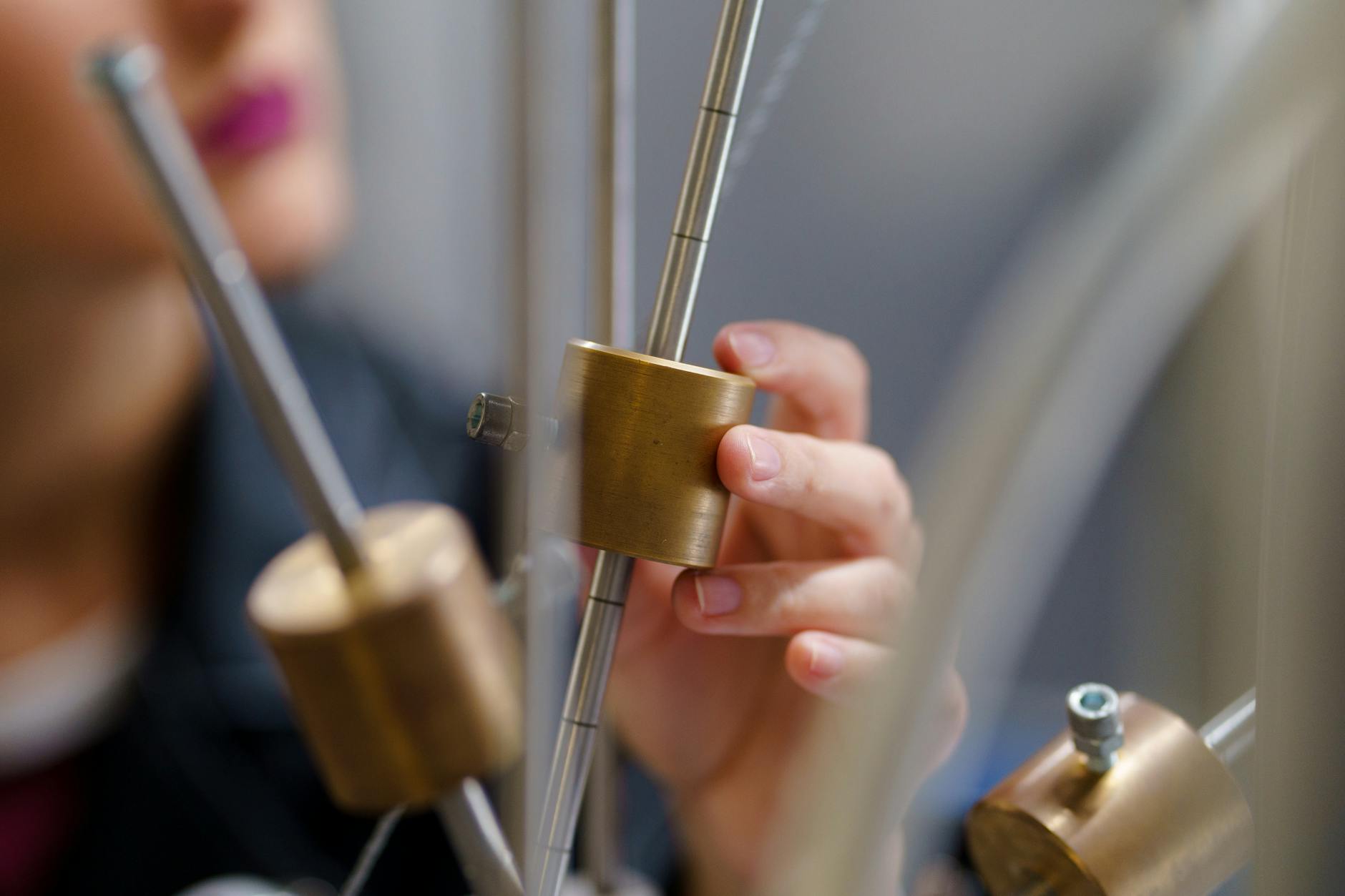 Uczeń wykonuje doświadczenie z fizyki z mosiężnymi elementami