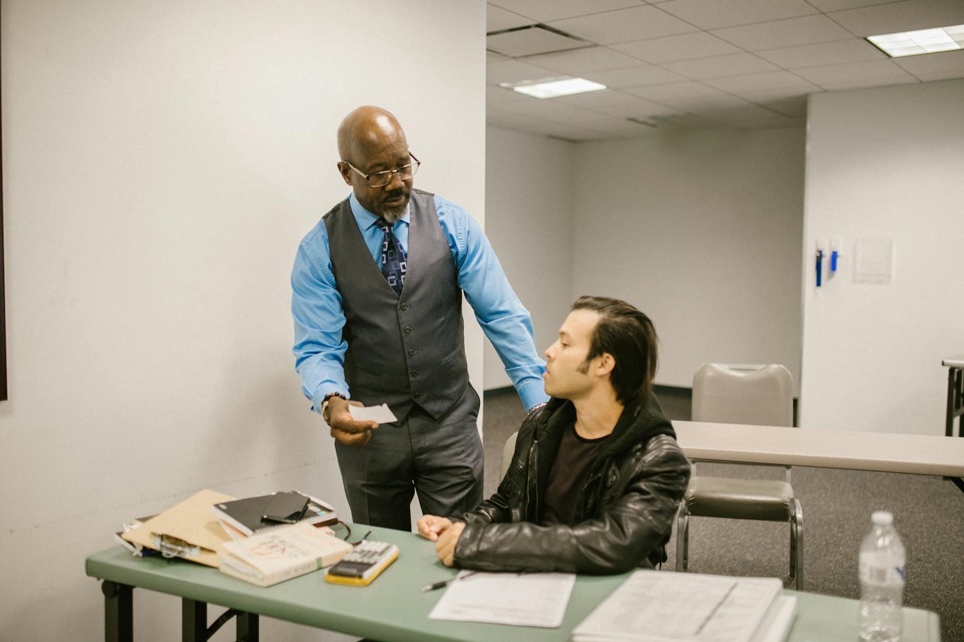 Nauczyciel rozmawia z uczniem przyłapanym na ściąganiu podczas egzaminu