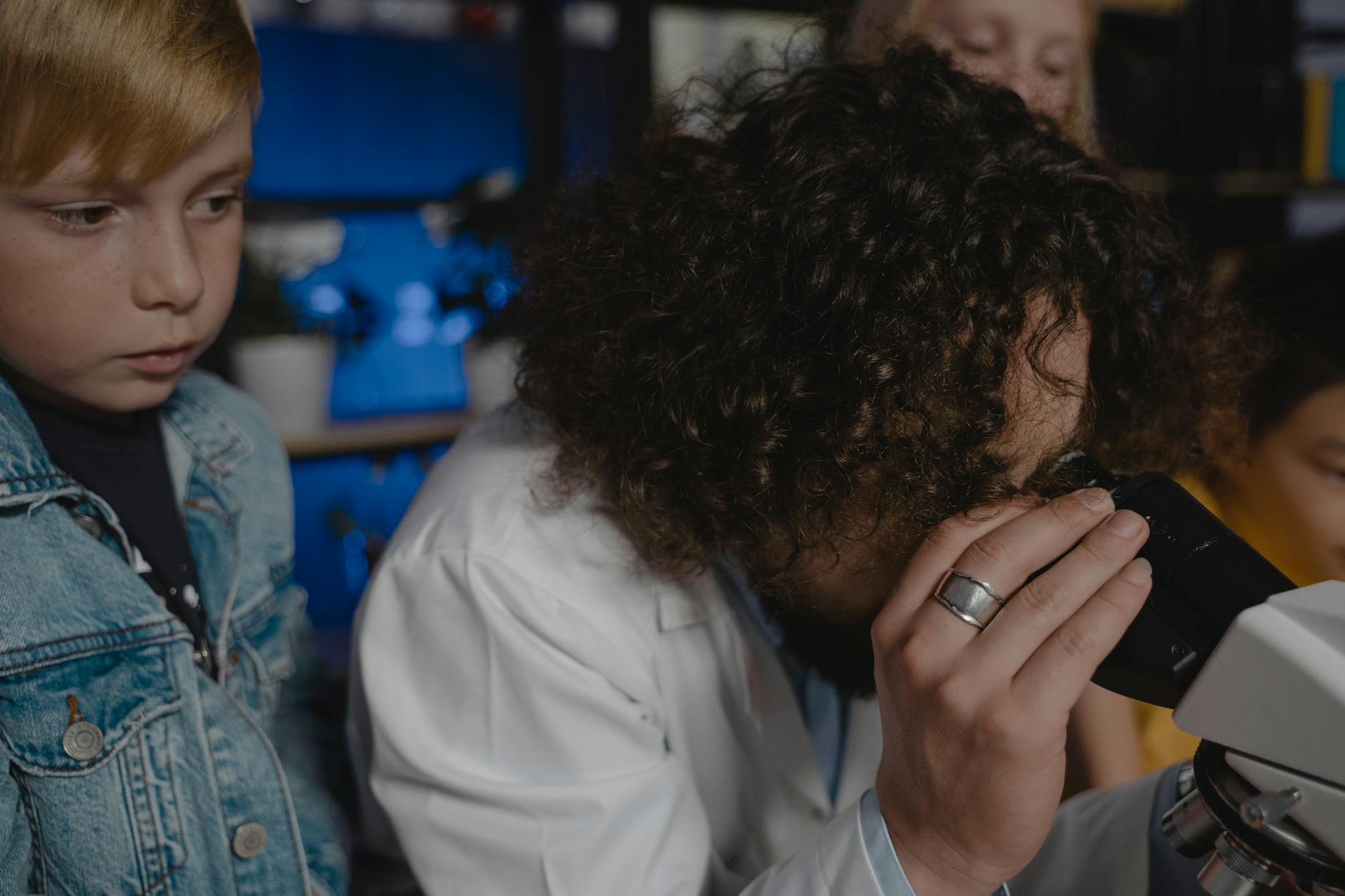 Uczniowie z nauczycielem obserwują doświadczenie biologiczne w klasie